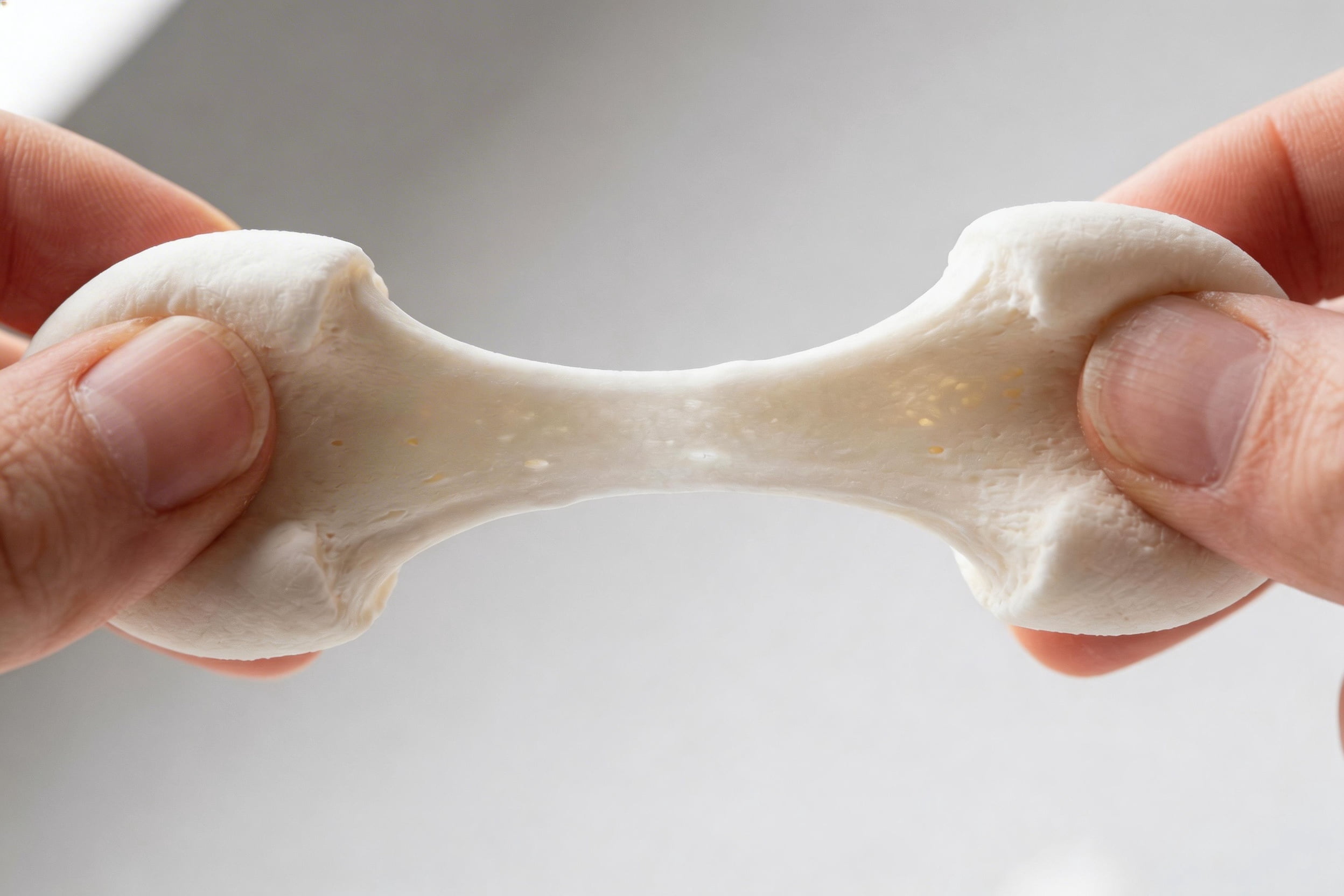 The Role of Gelatin in Marshmallow Texture Close-up of a marshmallow being stretched to show its elasticity